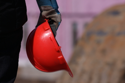A construction worker holding a hard hat