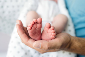 Unrecognizable father with newborn baby son.