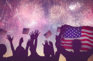 Silhouettes of people holding the Flag of USA.