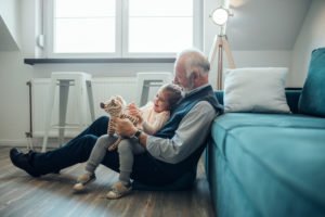 Elderly man holding his granddaughter